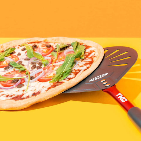 Pro Grade 9 Inch Perforated Pizza Peel With Extendable 27 To 41 Inch Handle For Indoor And Outdoor Ovens, Lightweight Aluminum Turning Peel, Nonstick Metal Pizza Turner Red TKC holding pizza