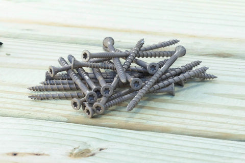 DSVT4MB Deck-Drive DSV Wood Screw 10 x 4 Inch Flat Head T-25 with Quik Guard Tan scattered on wood surface
