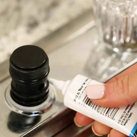 Danco 80360 waterproof faucet grease, 1/2 oz, white tube with barcode near chrome faucet valve