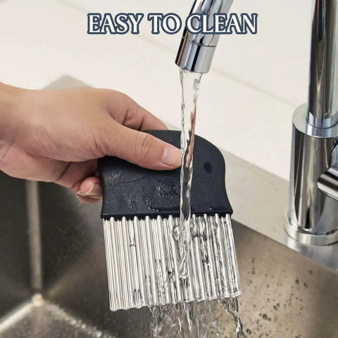 Stainless Steel Crinkle Cutter For Fries And Veggies Large Wavy French Fry Slicer With Non Slip Handle being washed under faucet