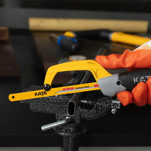 Compact Mini Hacksaw For Metal Cutting With 10 Inch Aluminum Frame And Two Bi Metal HSS Blades Lightweight Ergonomic Grip Easy Blade Change Perfect For Wood PVC Iron Copper And Other Small Cutting Jobs in use for cutting metal pipe with orange-gloved hand