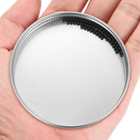 Silicon nitride ceramic bearing balls, 2.381 mm, black, arranged along the inner rim of a metal lid