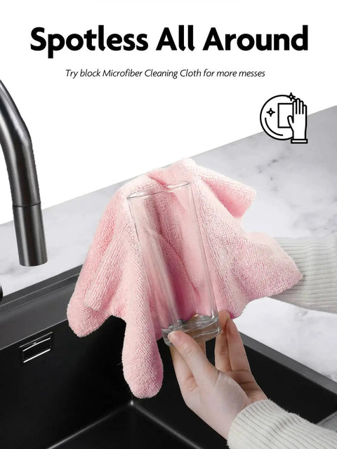 Person cleaning glass with pink Ultra Absorbent Microfiber Cloth Roll Tear Away Towels 12x12 Pink Grey Reusable by a kitchen sink.