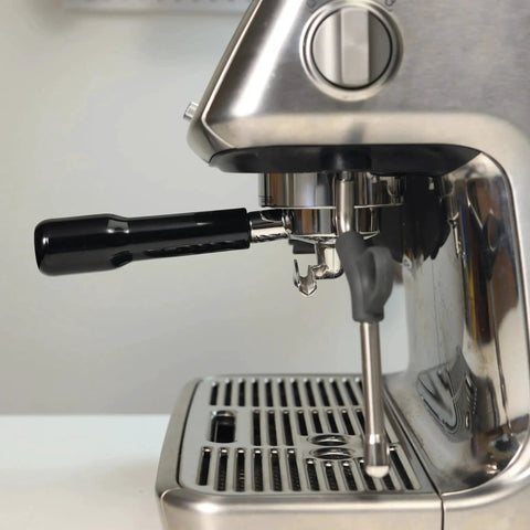 54mm portafilter with black ABS handle installed on a stainless espresso machine; double-spout.