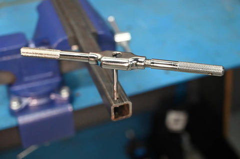 Close-up of One Eighth To Twenty Seven NPT And Twenty One Sixty Four Combo Pipe Thread Tap in use for cutting threads