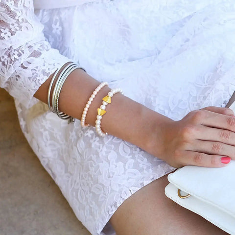 Woman wearing bracelet with Bright Golden Mixed Flower Spacer Bead Caps Set Alloy Cone Bead Caps Jewelry Findings for DIY crafts.