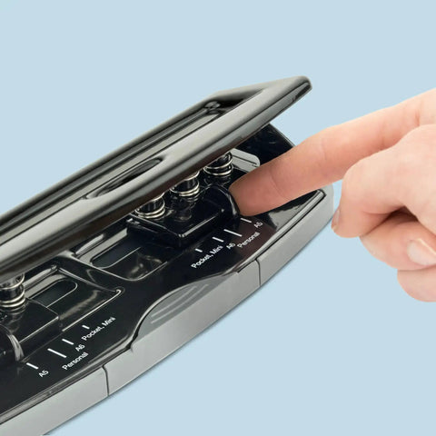 Close-up of the adjustable 6-hole punch with lock-down handle, showing the 4 position settings for A5 A6 Compact Slimline binders, black.