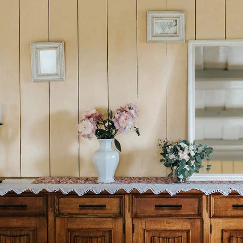 Wooden cabinets with vase and flowers, showcasing cabinet pulls. 32 Pack 6 Inch Cabinet Pulls Matte Black Stainless Steel Kitchen Cupboard Handles With 3.75 Inch Hole Center For Easy Replacement And Upgrading Cabinets And Drawers Durable Rust Resistant Hardware.