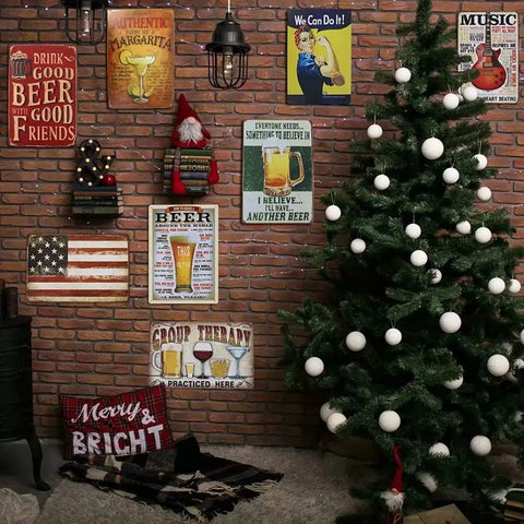 Christmas tree next to a brick wall with various vintage-style tin signs including beer and margarita themes, and holiday decor.