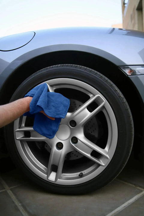 Person wiping car wheel with blue cotton towel from 150 Pack Cotton Shop Towels 14 By 12 Inches Absorbent Rags For Auto Shops Garage Home And Industry Cleaning Multipurpose Reusable Towels For Spills Machinery Wipe Downs And General Cleanup Blue