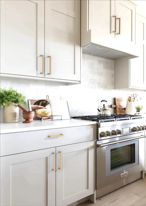 Kitchen with Champagne Bronze Cabinet Pulls 5 Inch 128mm Solid Zinc Alloy Handles installed on white cabinets and drawers.