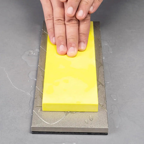 Hands using Extra Coarse 220 Grit Diamond Lapping Plate 10 X 4 Inch for whetstones flattening on a wet surface