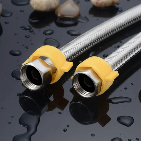 Close-up of two metal braided hoses with yellow plastic fittings on wet surface, used in plumbing and automotive repairs.