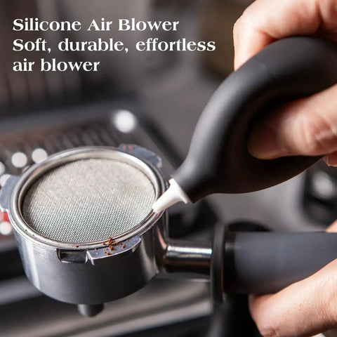 Hand using silicone air blower on portafilter from 7 Piece Espresso Tools Kit For 54mm Breville Portafilters Includes 53.3mm Tamper Distributor Puck Screen Dosing Funnel WDT Tool Perfect Home Barista Gear
