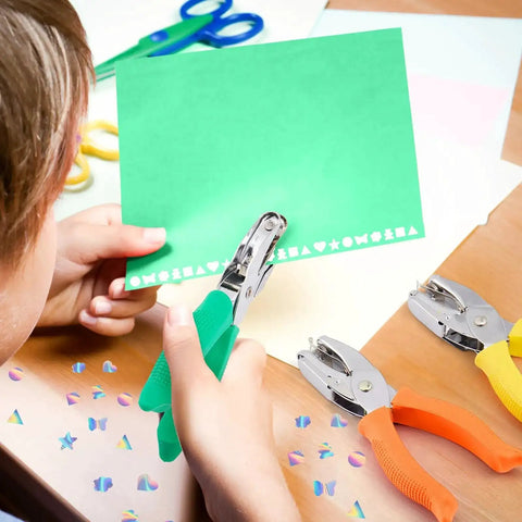 Child using Eight Piece Hole Punch Set With Shaped Punchers For Craft Lovers Handheld Metal Paper Punch With Grippy Handle on green paper.