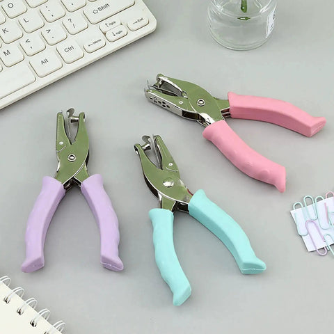 One Quarter Inch Circle Hole Punch, Metal Handheld Paper Punch with soft grip handle, shown in pink, blue, and purple on desk