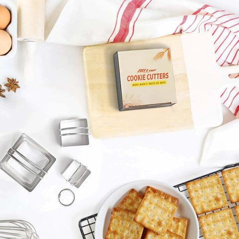 Five Piece Stainless Steel Biscuit Cutter Set With Handle For Easy Square Cookie Shaping And Cake Decorating Includes 4 5 6 7.5 And 8 Cm Cutters Made From 18 8 Stainless Steel Durable Rust Resistant For Bakers Who Bake Like A Pro From ALLTOP displayed on a kitchen counter with square cookies.