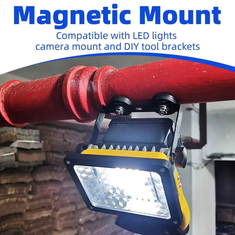 Installed view: LED work light with yellow and black housing mounted on a red pipe using a rubber-coated magnetic mount.