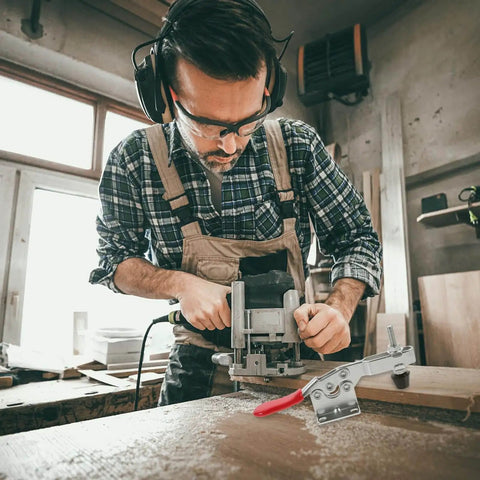 Woodworker using a router with a 10 Piece Quick Toggle Clamps Set For Vertical Downward Push Heavy Duty Hold Downs on a wooden surface