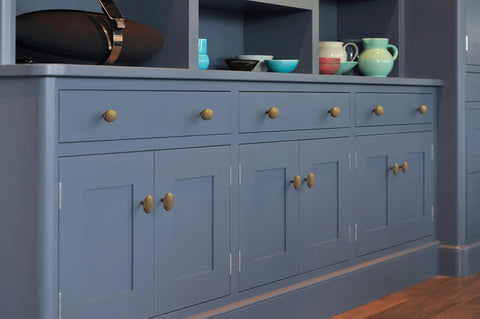 Six Pack Zinc Alloy Drawer Knobs in Big Oval Antique Brass Finish for Cabinets and Furniture shown on blue kitchen cabinets.