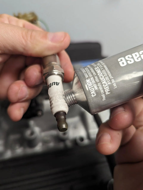 Permatex 3 oz dielectric tune-up grease applied to spark plug boot; white silicone paste