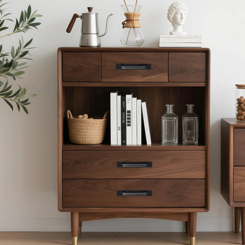 Mid-century modern wooden cabinet with books, basket, and glass bottles, accented by plants and decorative items on top.