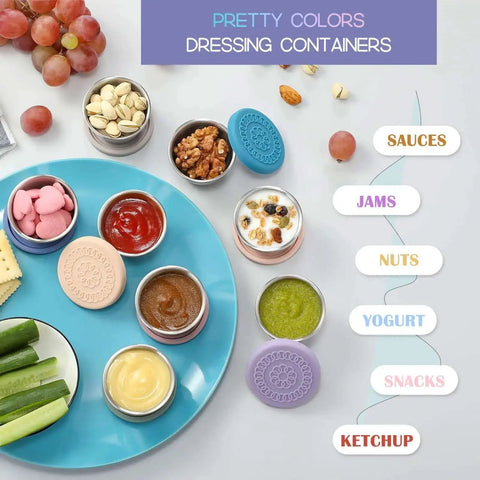 Eight Pack 2.4oz Stainless Steel Condiment Containers With Leakproof Silicone Lids displayed with sauces, nuts, and snacks