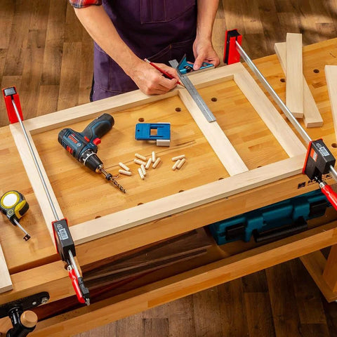 Woodworker using One Half Inch Doweling Jig Kit With Drill Bit And Stop Collar For Rock Solid Joints End Or Edge Reference Stops on table