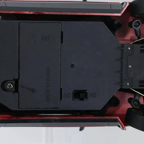 Underside view of One Eighteen Scale RC Drift Car With Gyro Stabilization In Vintage Red showing chassis and components