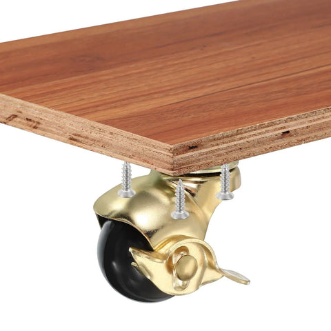 1.5 Inch Ball Caster Wheels With Brake, gold finish, mounted on wooden board, 360 degree swivel, includes M4 screws