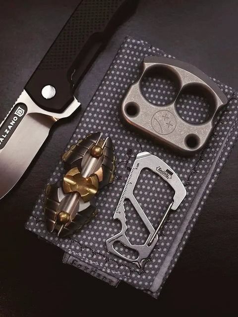 Stainless Steel 7 Tool Carabiner Clip Multitool with knife, brass decor, and metallic item on patterned fabric background