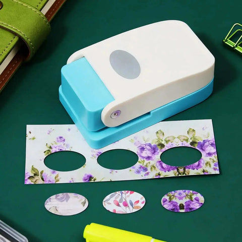 Portable Oval Tab Punch for Scrapbooking and Card Making cutting floral paper on a craft table.