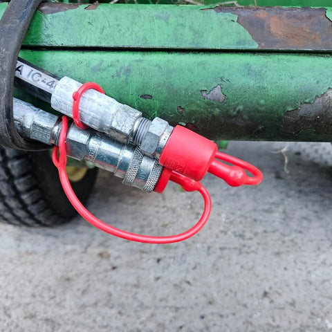 Dust caps for 1/2 in flat-face hydraulic quick-connect couplers; red rubber covers on male and female ends