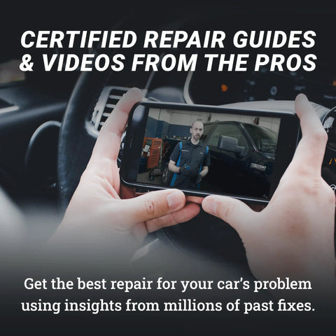 Person holding a smartphone displaying a car repair video, demonstrating guidance for vehicle issues.