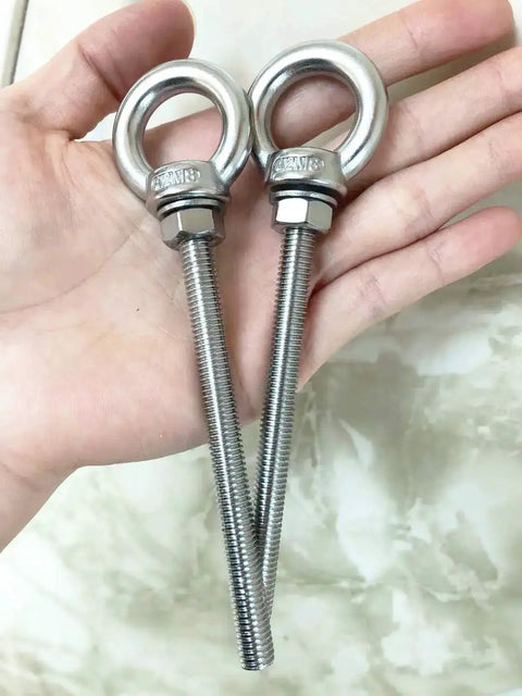 Hand holding two Shoulder Eye Bolts M8 Stainless Steel Built Tough Heavy Duty With Washers And Nuts for lifting and securing cables.