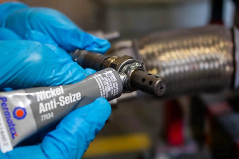 Applying Nickel Anti Seize Lubricant For Threads And Fasteners With High Temperature Protection In A Half Ounce Tube on a metal pipe