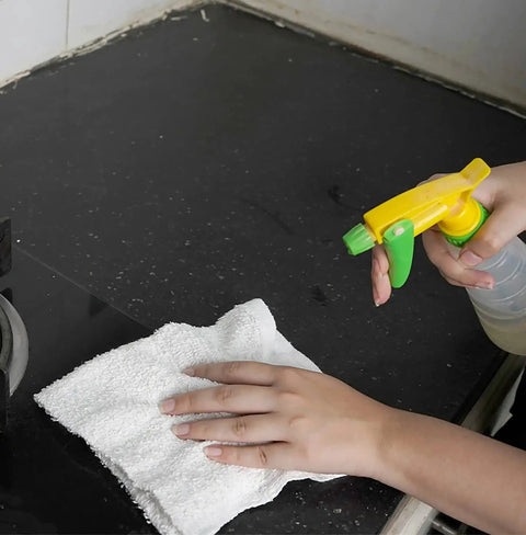 Person cleaning counter with white linen terry bar mop towel 14x17 from value pack of 60, using spray bottle