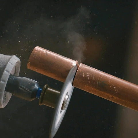 EZ Lock Rotary Tool Cut Off Wheels Kit By Dremel cutting copper pipe, fiberglass-reinforced wheel close-up in action