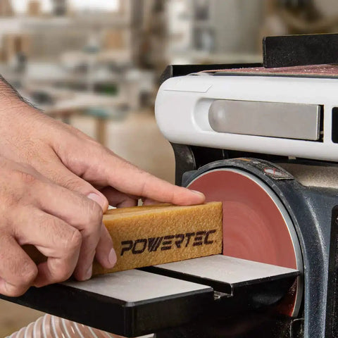 Hand using Abrasive Cleaning Stick For Sanding Belts And Discs Eight And A Half Inches Natural Rubber Eraser on sanding machine