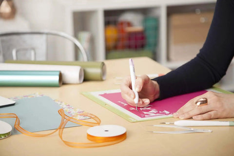 Person using Go-To 5-Piece Craft Tool Set for Precision Lifts Snips Burnish and Weed by Cricut, Ideal for Vinyl Projects in Mint