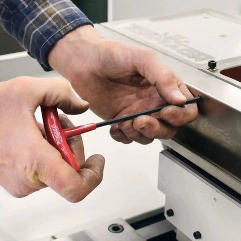 Person using Eight Piece Balldriver And Hex T-Handle Set 2 To 10 Millimeter Sizes With Cushioned Grips for fastening a machine