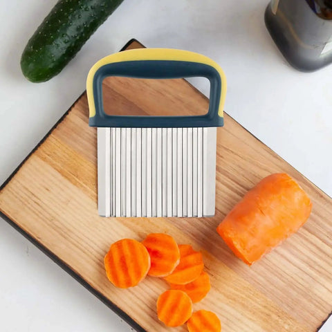 Crinkle Cutter Wave Knife on cutting board with sliced carrots, stainless steel blade, yellow handle and protective case; kitchen tool.