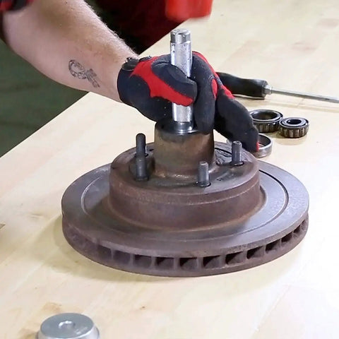 Mechanic using Bearing Race And Seal Driver Set With Nine Sizes Range From 1.565 To 3.180 Inches on wheel hub for installation