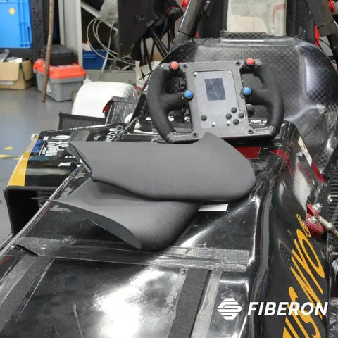 Close-up of a carbon fiber reinforced PET piece on a black racing car, showcasing Carbon Fiber Reinforced PET 3D Printing Filament 1.75mm 0.5kg Black PET-CF17 High Stiffness For Jigs And Fixtures Fast Printing Excellent Printability Wide Printer Compatibility For Strong Durable Parts.