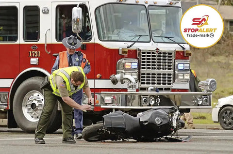 Firefighter and police officer responding to a motorcycle accident near a fire truck, illustrating the need for 60X Plus Universal Brake Flasher For Stop Bulbs And Tail Lights With Pre Programmed Patterns Rapid Flash Low Flash And Steady LED Relay Upgrade So Your Ride Stands Out On Any Car Truck Or Motorcycle 5 Amp 60 Watt.
