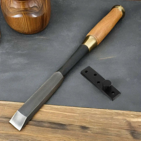 Wood chisel tool with wooden handle and black metal hinge on wooden surface