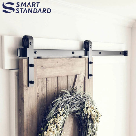 Heavy Duty 5ft Sliding Barn Door Hardware Kit With Track Kit, Pull Handle Set, And Floor Guide, shown installed on wooden door