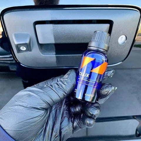 Close-up of DLUX Wheel and Trim Ceramic Coating 30mL bottle with UV protection for alloy wheels, plastics, rubber, metal surfaces.
