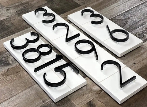 5 Inch Stainless Steel Floating House Number With Nail Kit Coated Black 911 Sign displayed on wood surface
