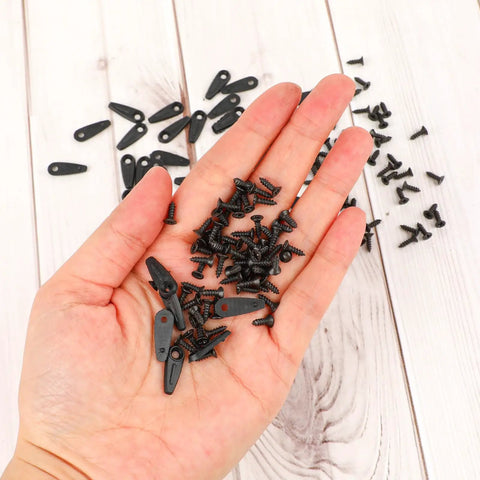 Hand holding 50 Pcs Picture Frame Backing Clips With Screws Black Turn Button Hardware For Hanging Photos Artwork Gift Boxes And Decoration Boxes Easy Install Durable Plastic Frame Fasteners 18mm Long 7mm Wide 8mm Screws